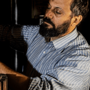 Dario Orzan operating his family's hand-screw wine press